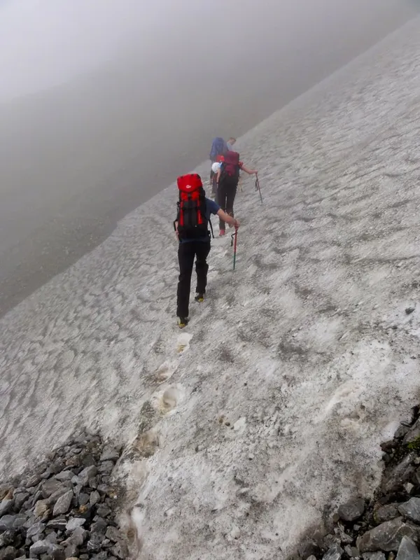 Querung eines steilen Altschneefeldes beim Hüttenzustieg