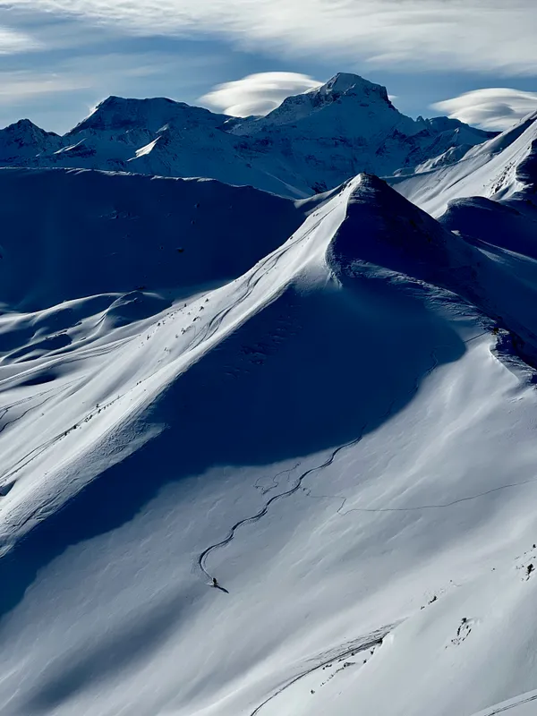 Auf dem Nachbargipfel zieht ein anderer Tourengänger seine Spuren in den frischen Schnee. Hinten der Piz Sardona.