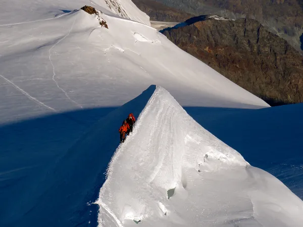 Eine Seilschaft im Aufstieg zur Ludwigshöhe. Dahinter der Roccia della scoperta (Entdeckungsfelsen)